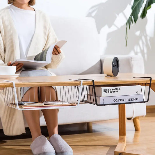 Person sitting on a couch reading a book with a coffee table in front of them featuring a magazine Storage Rack.